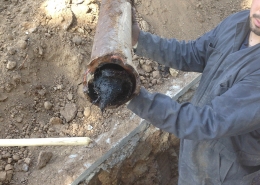Holding Up A Damaged Main Sewer Line Pipe With Tree Root Intrusion